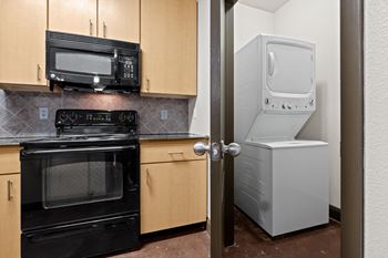 A kitchen with a refrigerator and a stove and a microwave